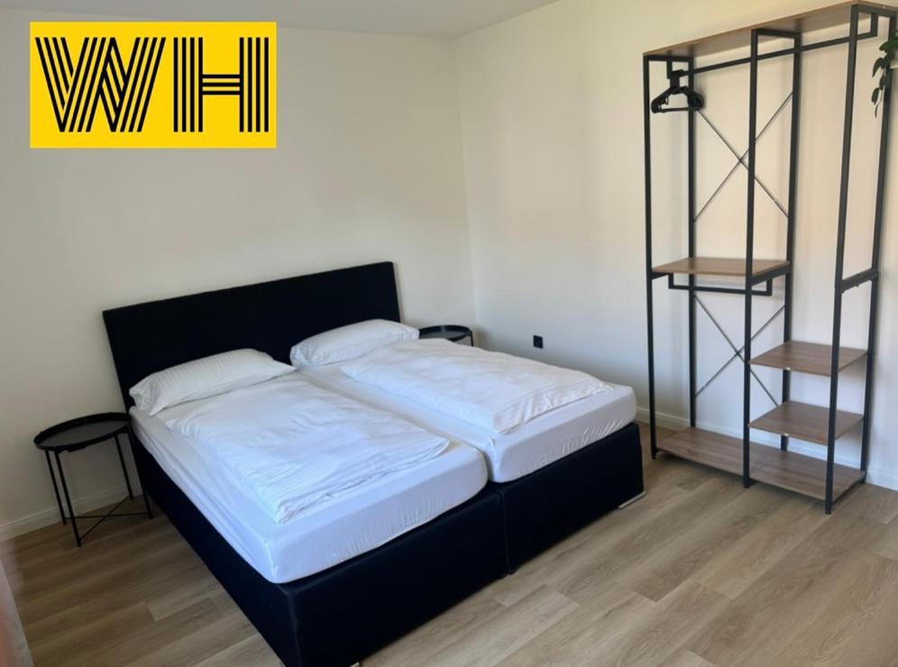 a bedroom with a bed with a black headboard and a shelf at Wohnung mit 4 Betten KÖ1 in Hannover