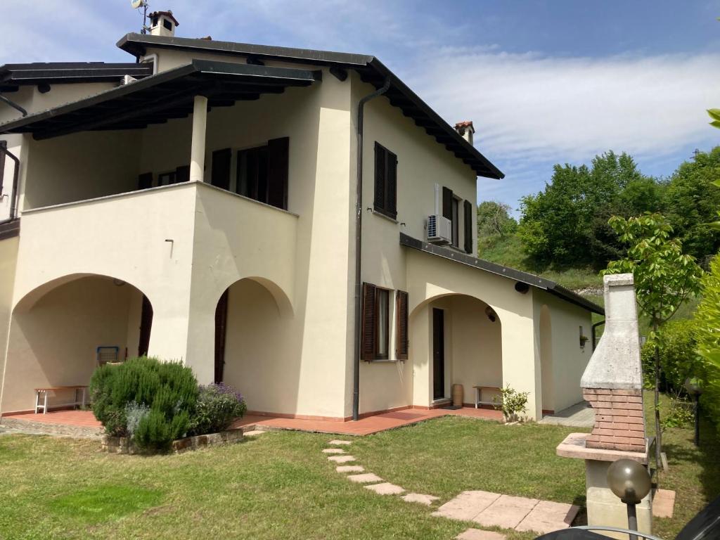 ein großes weißes Haus mit einem Rasenhof in der Unterkunft Villa Sasso Cavallo in Mandello del Lario