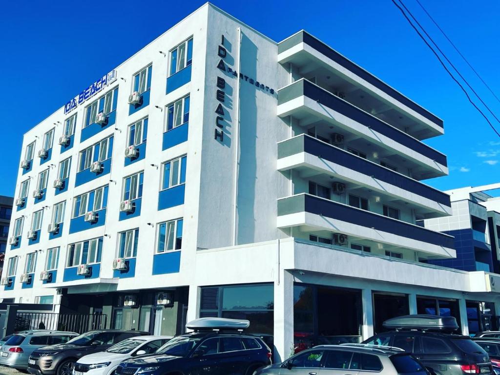 a building with cars parked in front of it at Ida Beach in Mamaia Nord