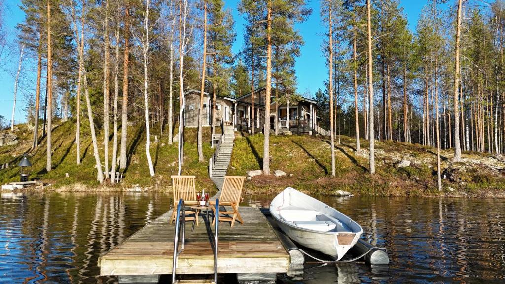 un barco sentado en un muelle frente a una casa en Villa Kolovesi - Saimaa Retreat en Savonlinna