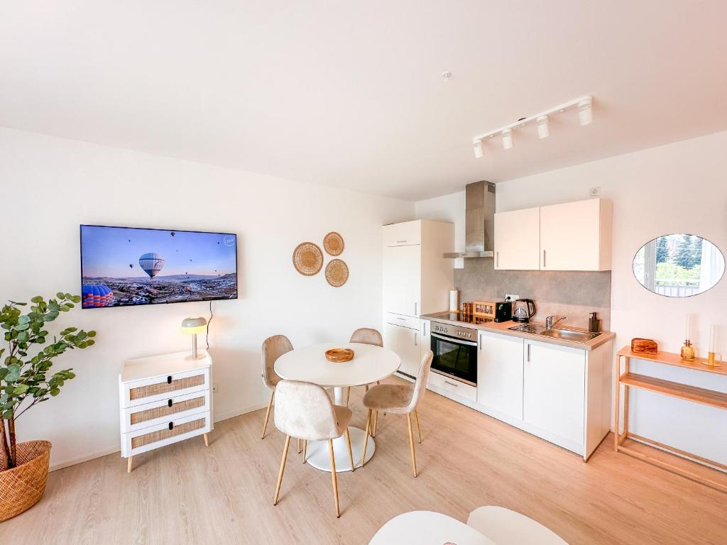 a kitchen and dining room with a table and chairs at theSunset Club - Studio II - Küche - Balkon - Parken in Memmingen