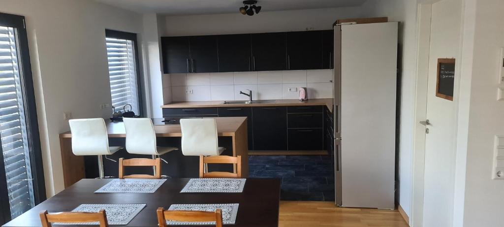 a kitchen with a table and chairs and a kitchen with black cabinets at Homestay K in Weil am Rhein