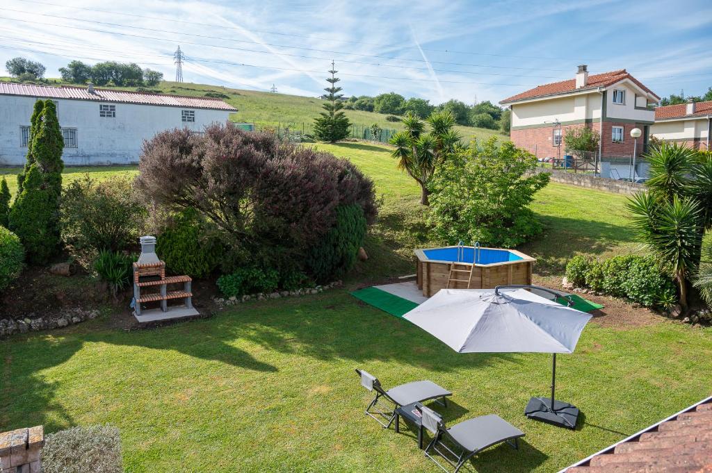 una vista aérea de un patio trasero con sombrilla y sillas en Casa entre Santander y Cabárceno con piscina en Revilla de Camargo