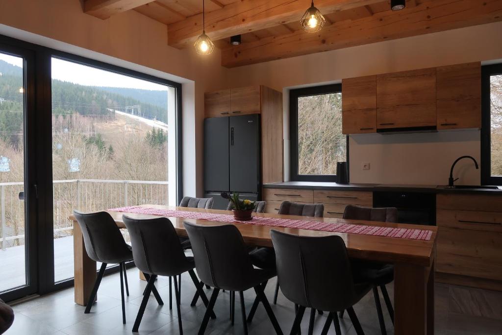 a kitchen with a large wooden table and chairs at Wellness chata Kouty in Loučná nad Desnou