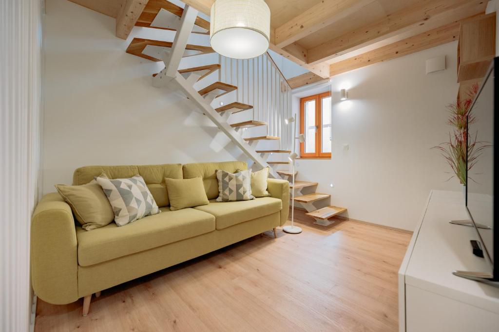 a living room with a couch and a staircase at BAY BREEZE Holiday house in Piran in Piran