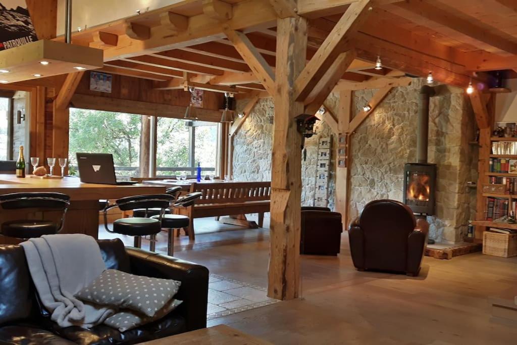 un salon avec une table et des chaises et une cheminée dans l'établissement 2 spacieux appartements dans une ferme rénovée face au MontBlanc, à Megève
