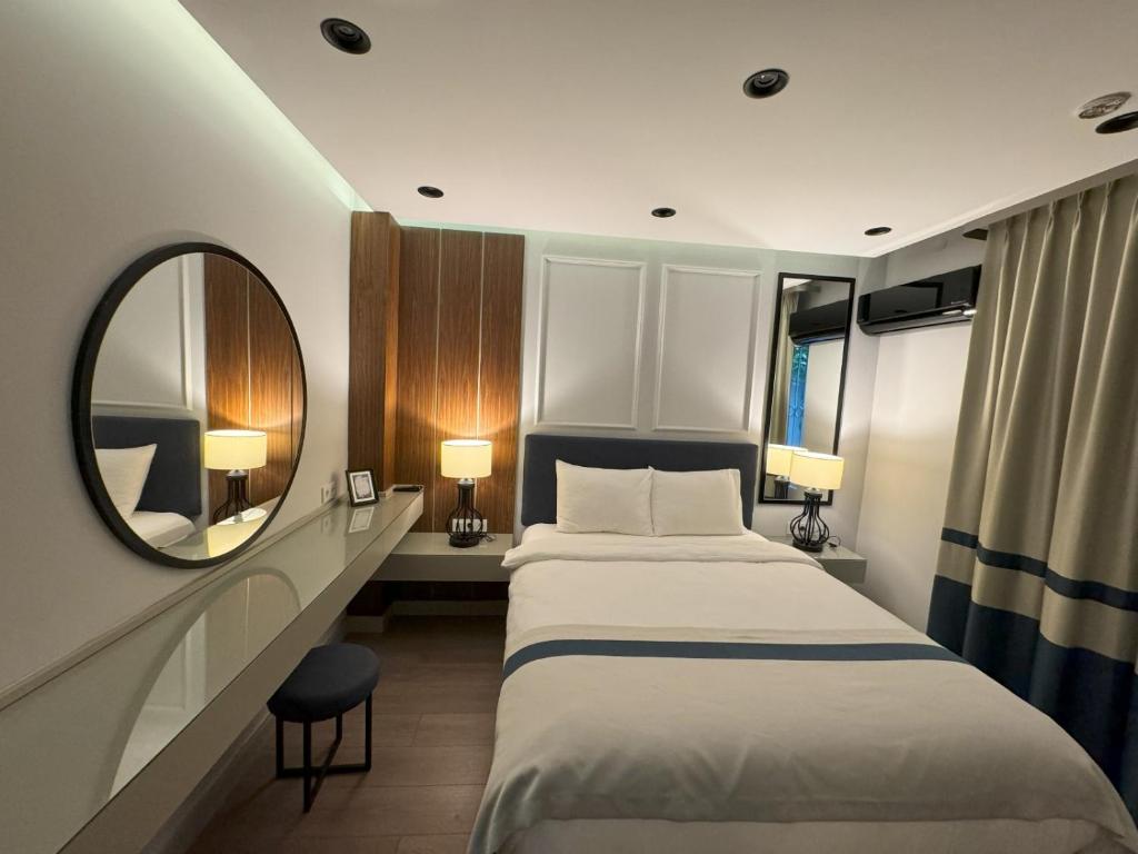 een hotelkamer met een bed en een spiegel bij relaxinn marmaris in Icmeler