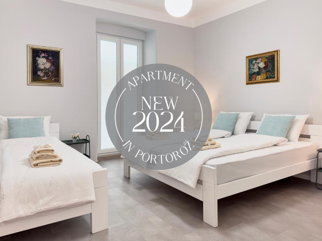a room with two beds and a sign for a new at Apartment Villa Elsa in Portorož