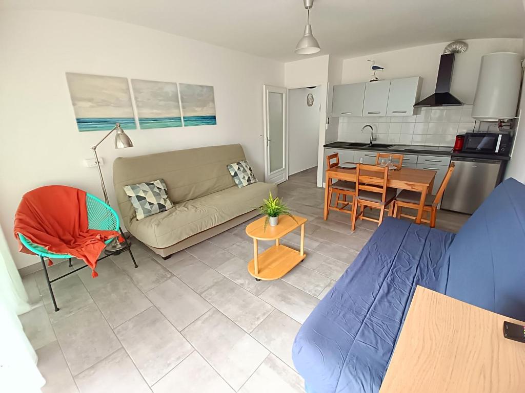 un salon et une cuisine avec un canapé et une table dans l'établissement Studio Palavas proche plages et centre - terrasse - Clim & Parking, à Palavas-les-Flots