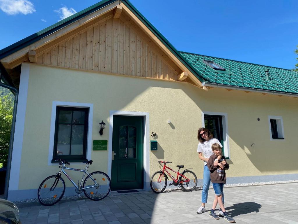 una mujer y un niño parados frente a un edificio en Cottage Bad Ischl - ab Juni 2024, en Bad Ischl