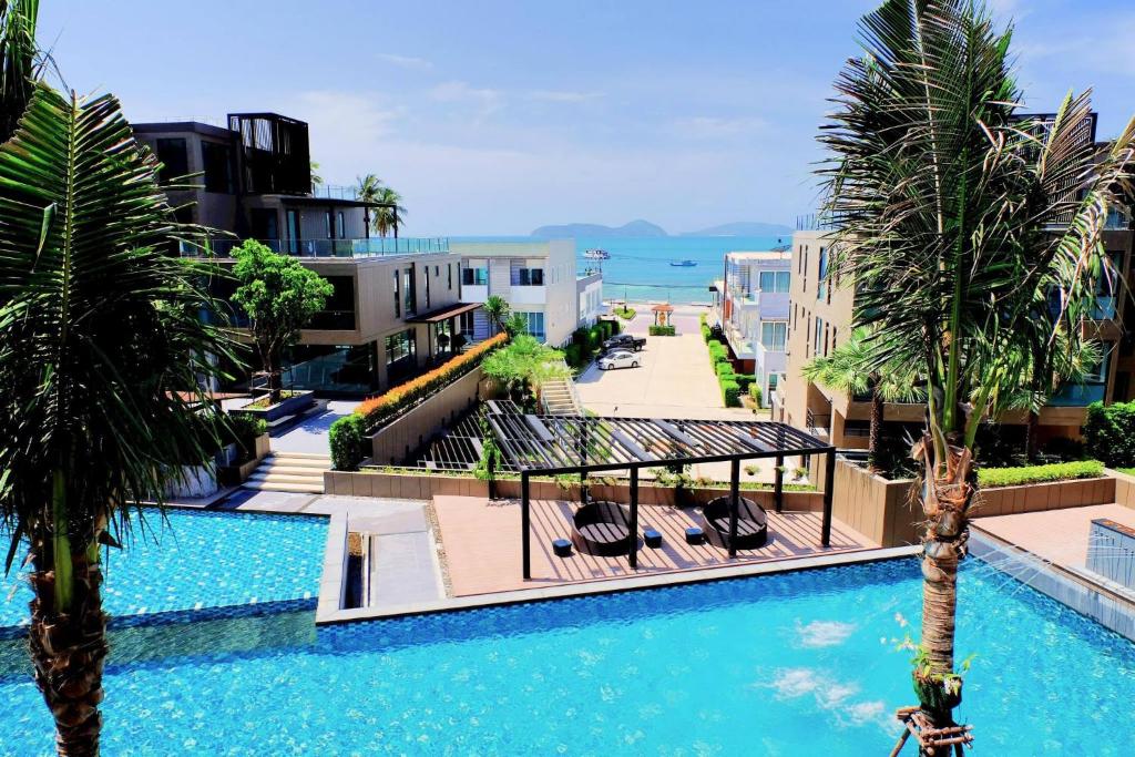 una piscina con palmeras y edificios en Seaview At Cape Panwa, en Panwa Beach