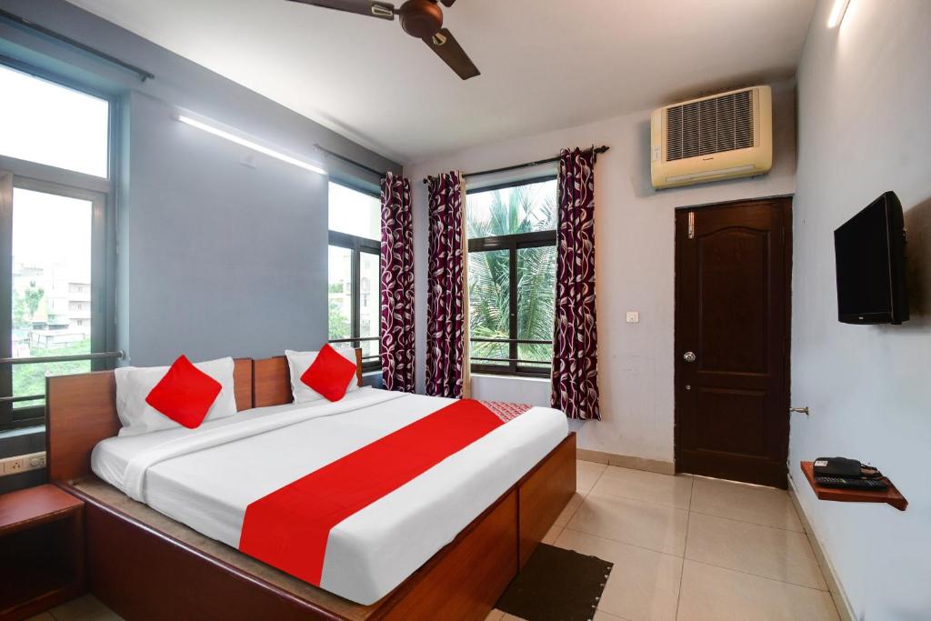a bedroom with a bed with red pillows and a tv at Urban Legends in Bārang
