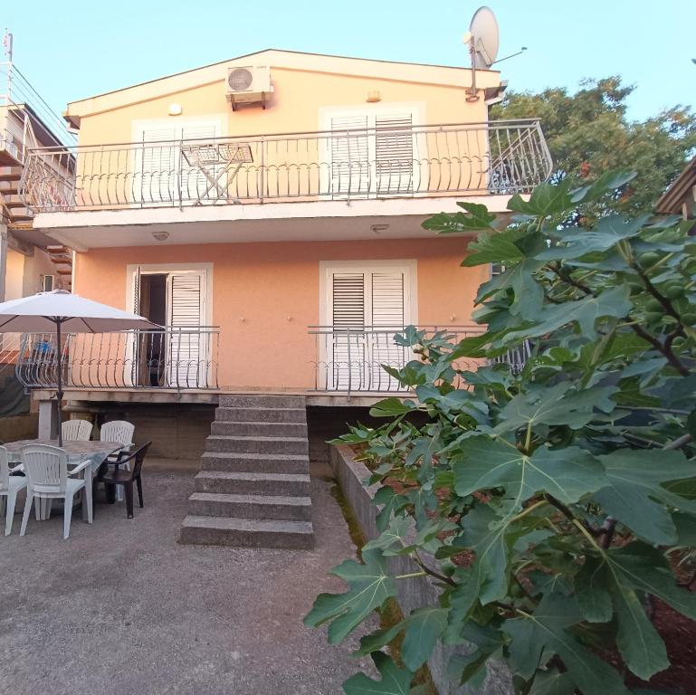 ein Haus mit einem Balkon, einem Tisch und Stühlen in der Unterkunft Villa Irina in Bar