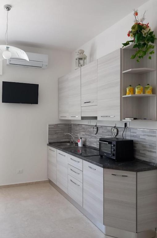 a kitchen with white cabinets and a black counter top at Casa Luce in Marina di Massa