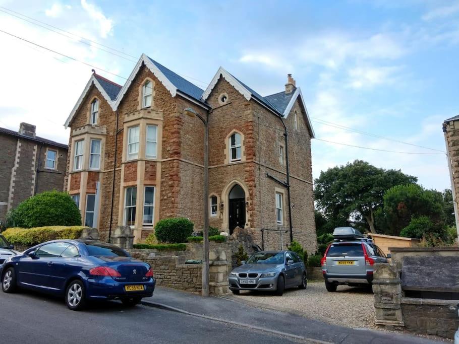 a brick house with cars parked in front of it at Beautiful Victorian Seaside House in Clevedon