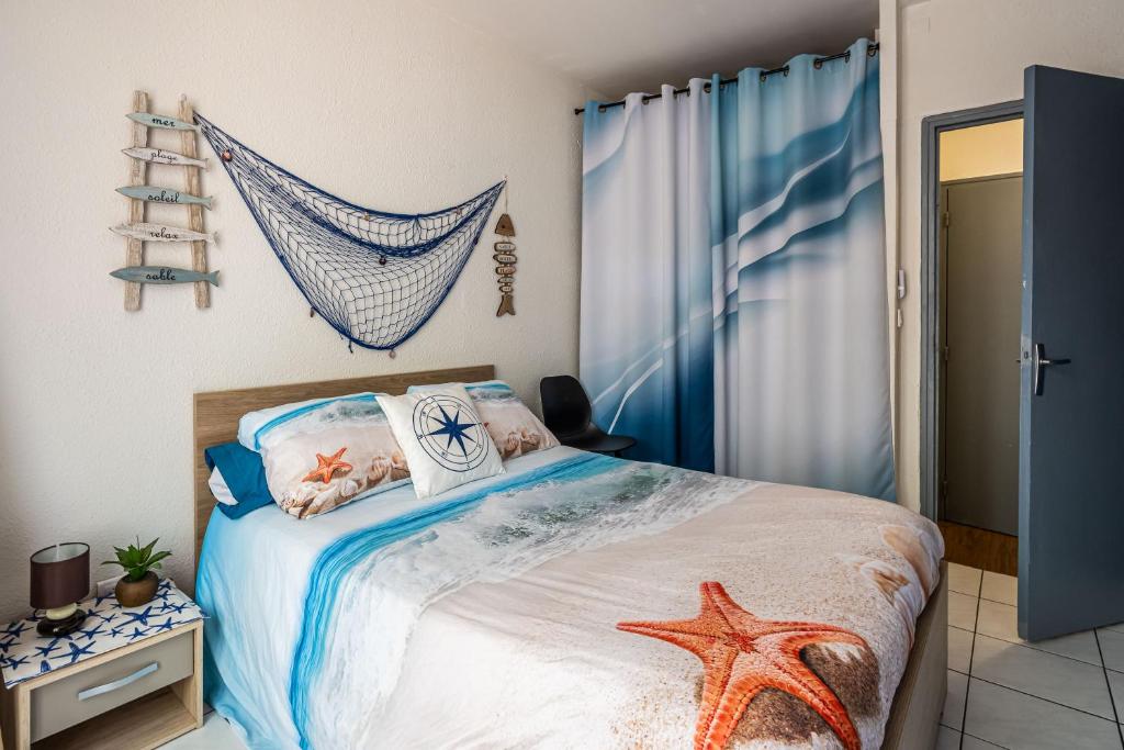 - une chambre dotée d'un lit avec une étoile de mer dans l'établissement La cabane bleue, T1 à Narbonne, à Narbonne