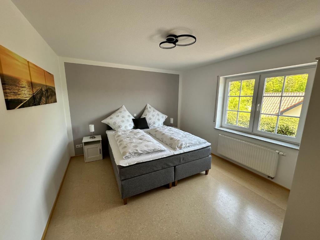 a bedroom with a bed and a window at Ferienwohnung Eifel-Ring in Siebenbach