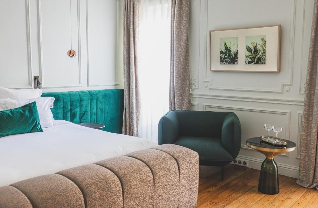 a hotel room with a bed and a chair at Hôtel Singulier Bordeaux - Boutique Hôtel & Spa Anne Semonin in Bordeaux