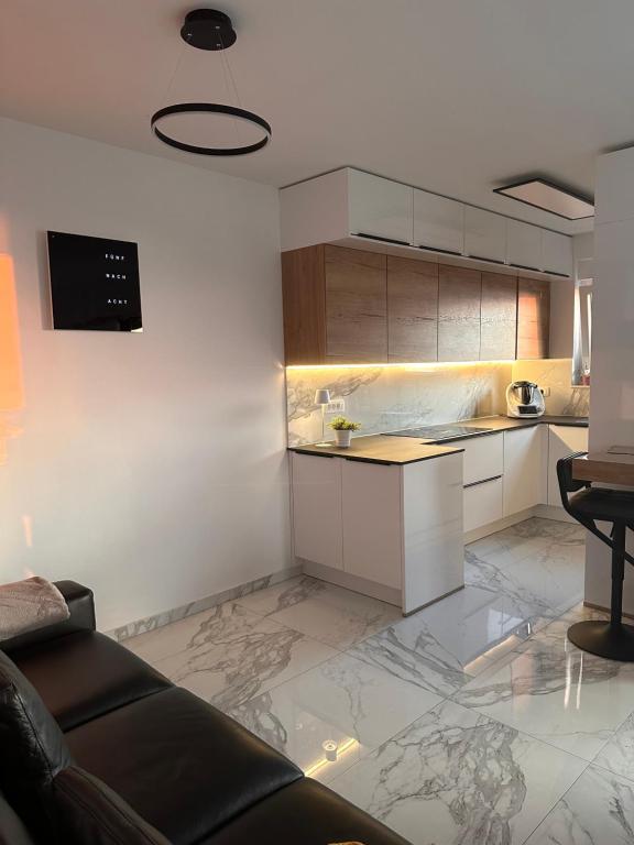 a kitchen with white cabinets and a couch in a room at Lili Rose Mandre Luxury Apartments in Mandre