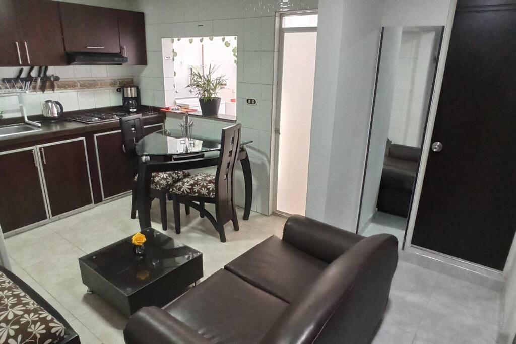 sala de estar con sofá y mesa en la cocina en Apartamento completo cerca a embajada 3, en Bogotá