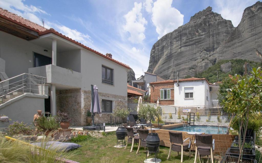 a house with a swimming pool in front of a mountain at 1951 Suites in Kalabaka