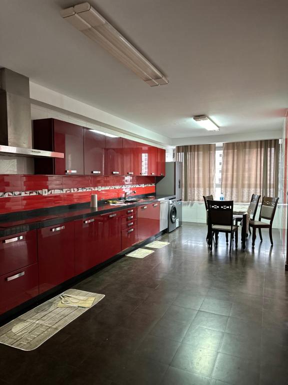 a kitchen with red cabinets and a table and chairs at Mobilart tour A etage 2 in Courbet