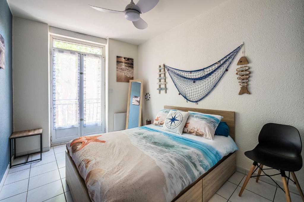 1 dormitorio con 1 cama y 1 silla negra en La cabane bleue, T1 à Narbonne, en Narbona