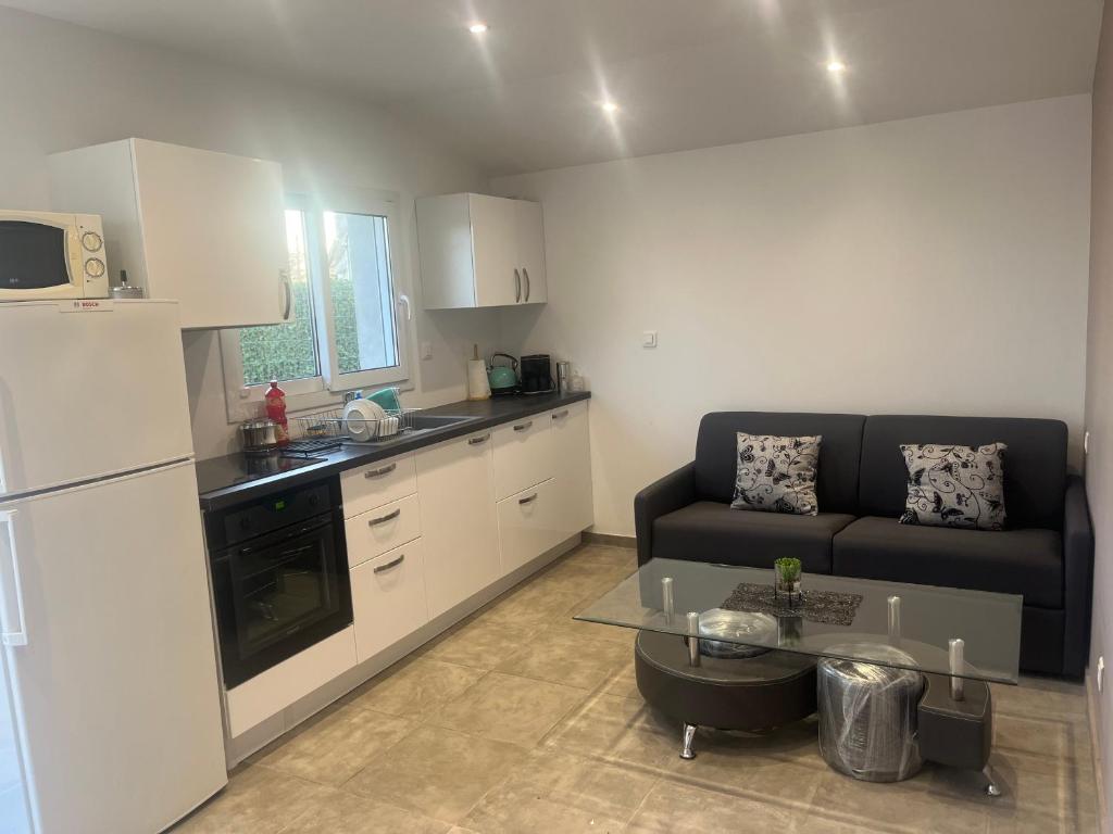 une cuisine et un salon avec un canapé et une table dans l'établissement Maison au calme, parking privée, à Saint-Rémy