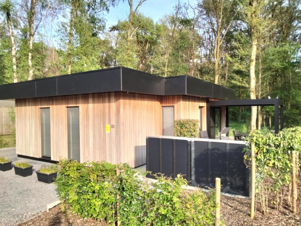 een klein huis met een zwart dak bij Theressa - Free Wifi en Netflix in Zutendaal