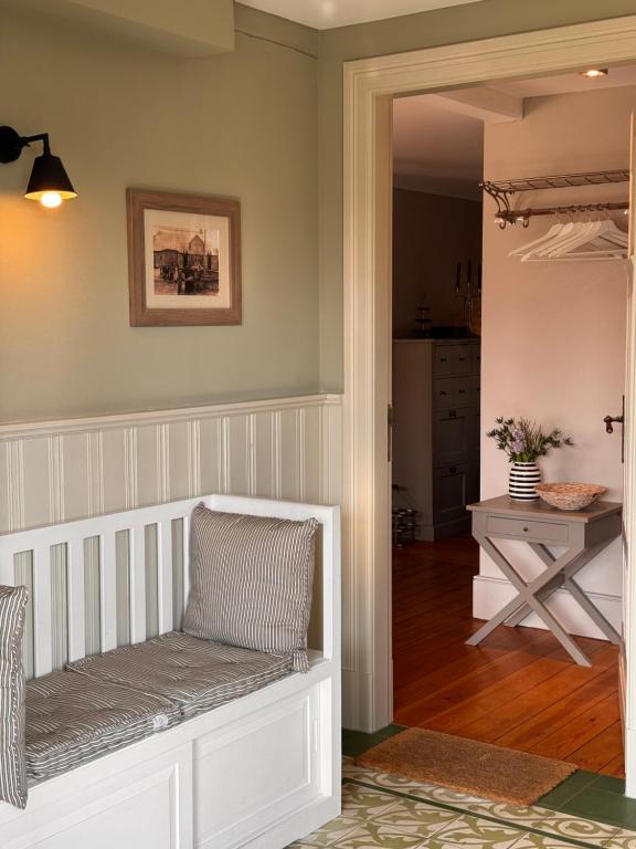 une chambre avec un banc blanc et une table dans l'établissement Kleine Perle, à Brodersby