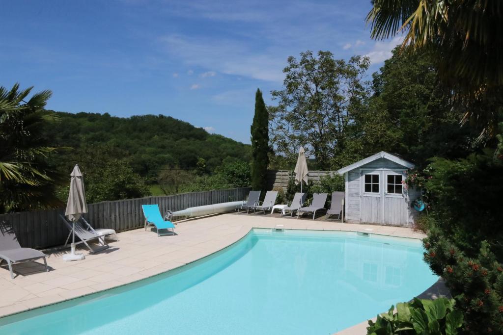 a swimming pool with chairs and a house at Le Clos du Noisillet in Cinais