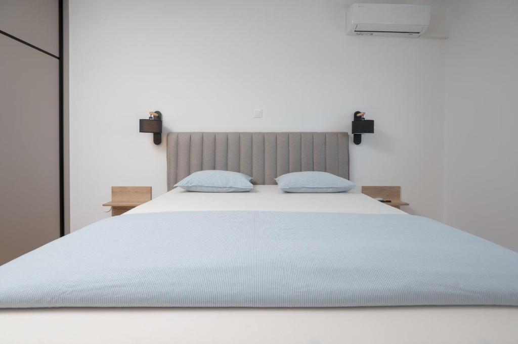 un letto bianco con due cuscini blu sopra di Lux Top Location Apartment Bridge a Zara (Zadar)
