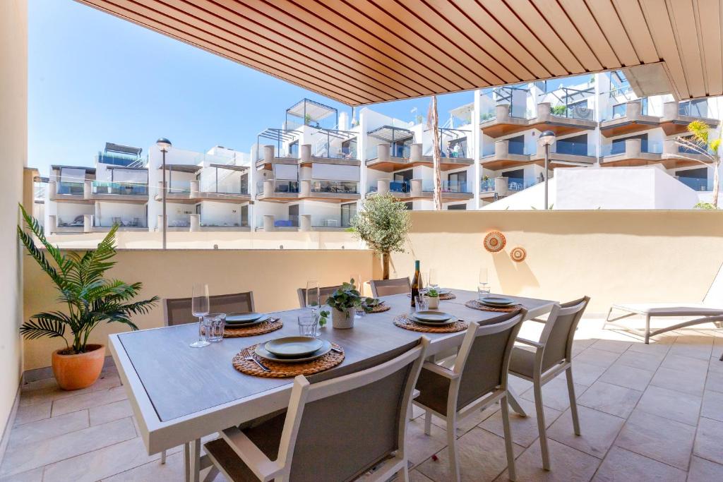 een tafel en stoelen op een balkon met een gebouw bij Casa Marinsa in Torrox Costa