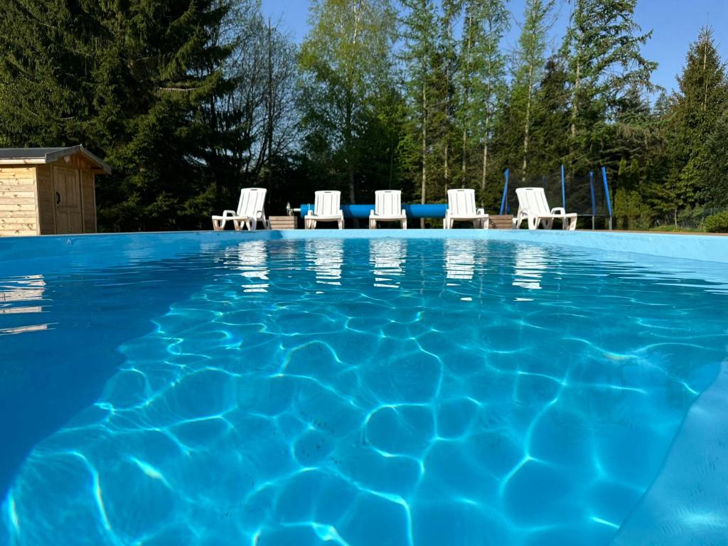 a swimming pool with chaise lounge chairs and a swimming pool at Dom Gościnny u Pierwienieckich in Pogorzelica