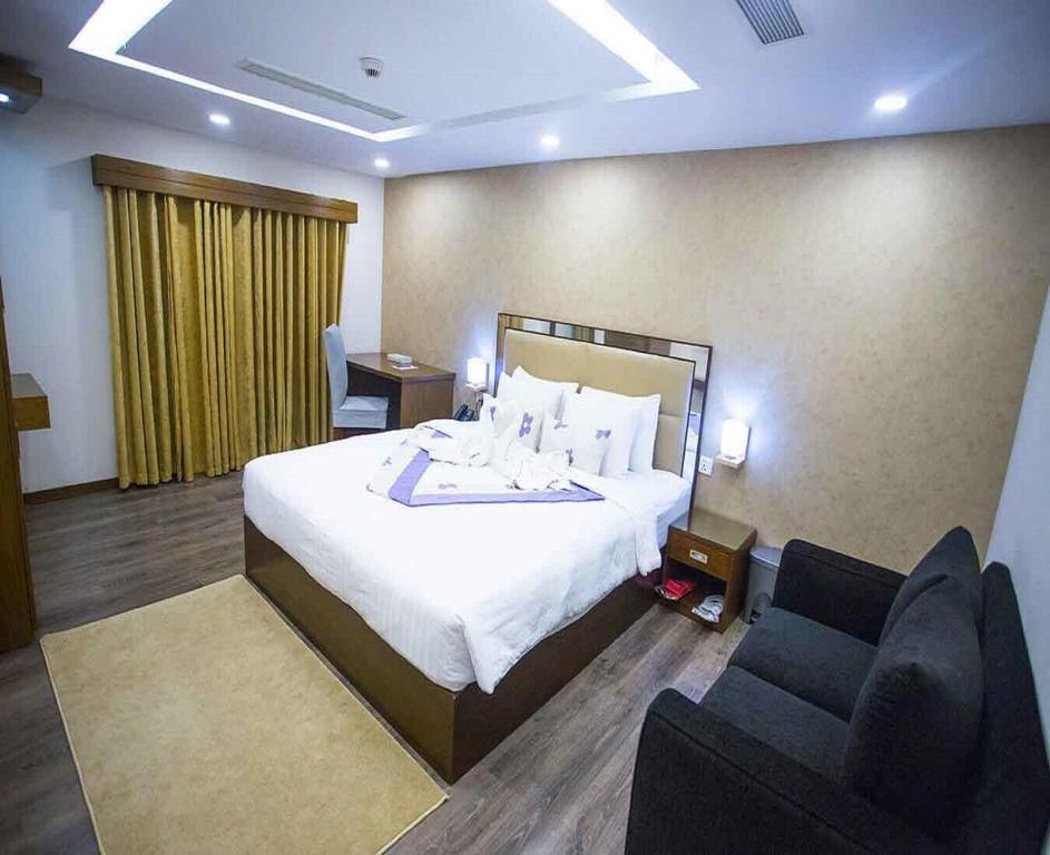 a hotel room with a bed and two chairs at Hotel AELA Suites "Cloud plaza" near Delhi airport in New Delhi