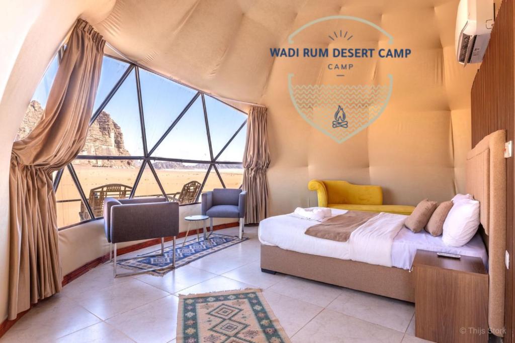 a bedroom with a bed and a large window at Wadi Rum desert camp in Wadi Rum