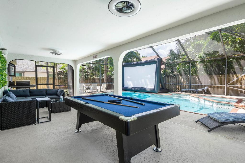 a living room with a pool table and a tv at Aster Equestrian Florida Home with Heated Pool/SPA in Wellington