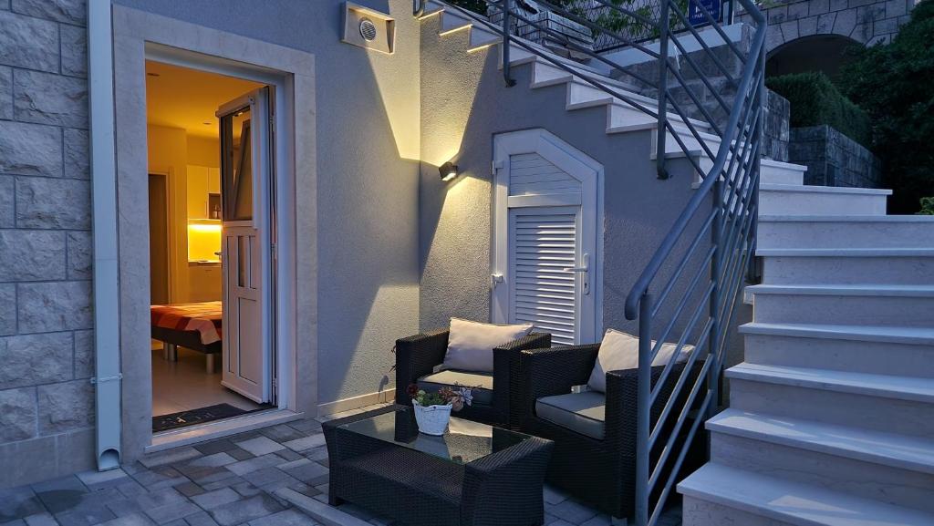 une terrasse avec une chaise, une table et des escaliers. dans l'établissement Vitis Apartments, à Zaton