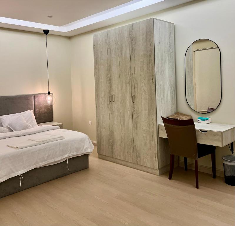 une chambre avec un lit, un bureau et un miroir dans l'établissement شقة جديدة وفاخرة بالقرب من الحرم ., à Sīdī Ḩamzah
