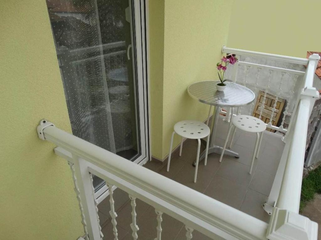 a small balcony with a table and two stools at Vila Jenic in Soko Banja