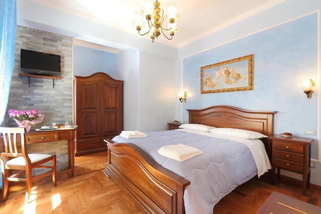 um quarto com uma cama, uma secretária e uma televisão em Katti House 2 em Florença
