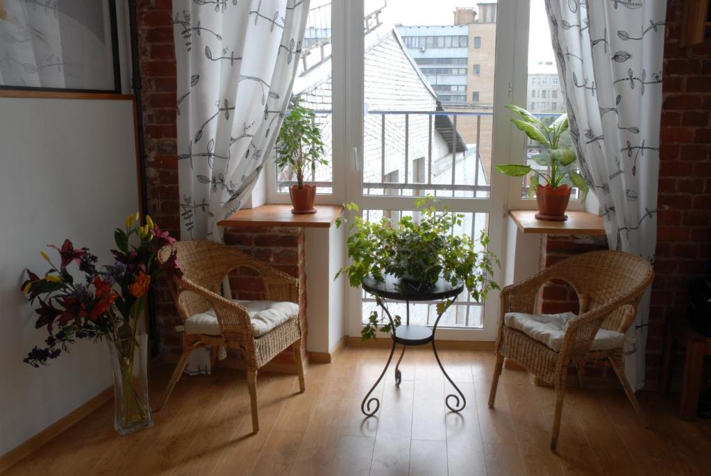 a room with chairs and potted plants and windows at Gostevoy Dom na Suhkharevke in Moscow