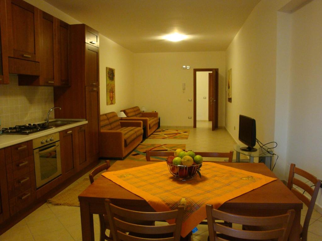 a kitchen and living room with a table with a bowl of fruit at Appartamenti Campo in Trappeto