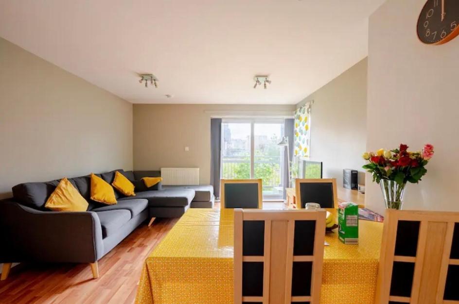 een woonkamer met een blauwe bank en gele kussens bij City centre 2 bedroom flat sleeps 7 with free parking in Edinburgh