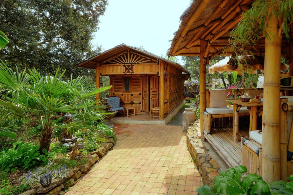 a wooden building with a pavilion in a garden at Coco Banane in Anduze