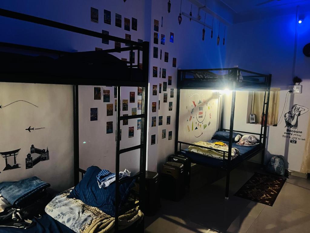 Cette chambre comprend 2 lits superposés et un mur orné de photos. dans l'établissement Spiritual Backpackers Hostel, à Ujjain