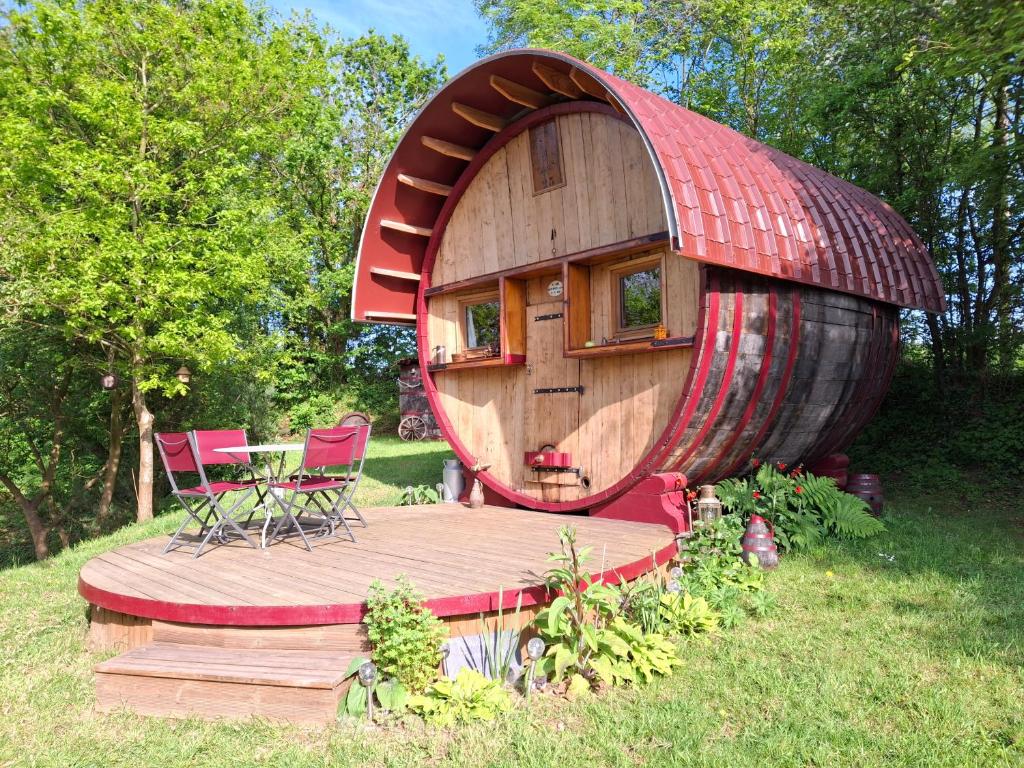 uma grande casa de hobbit de madeira com um telhado vermelho em L'authentique Tonneau à Cidre d'Emma em Litteau