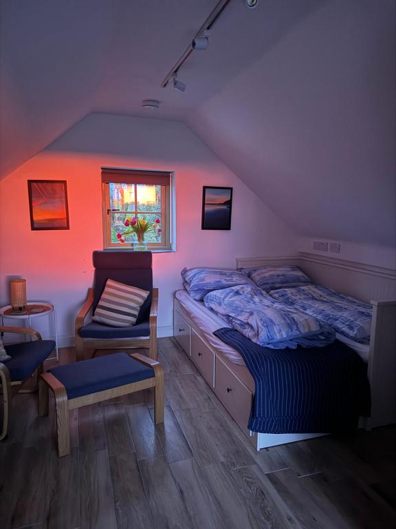 a bedroom with a bed and a chair and a window at Cwtch Lackerlee in Haverfordwest