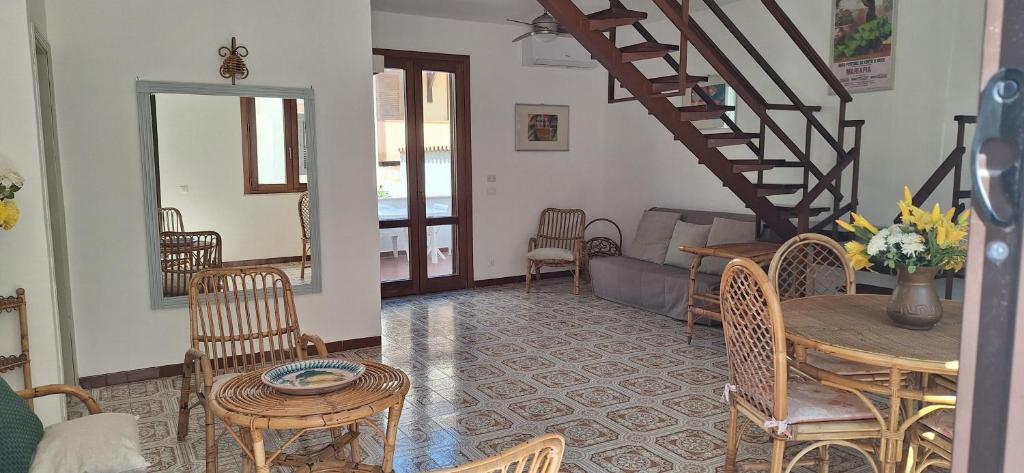 een woonkamer met een tafel en stoelen en een trap bij Casa al Mulino in San Vito lo Capo