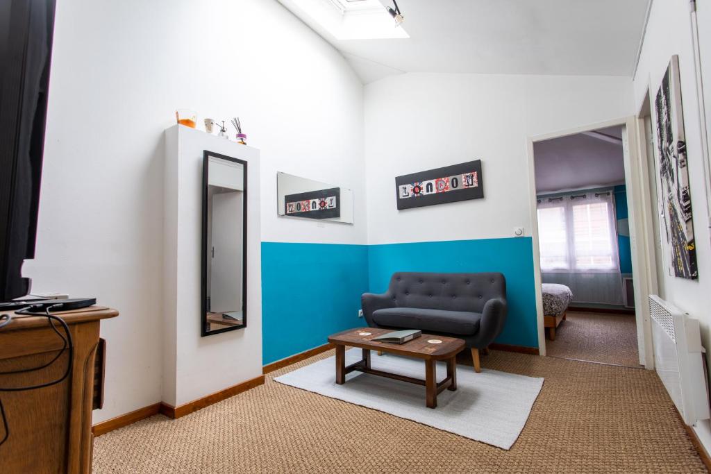 uma sala de estar com um sofá e um espelho em T2 Toulouse 40m2, Lit Queen Size, Climatisation, quartier sympa, Terrasse em Toulouse